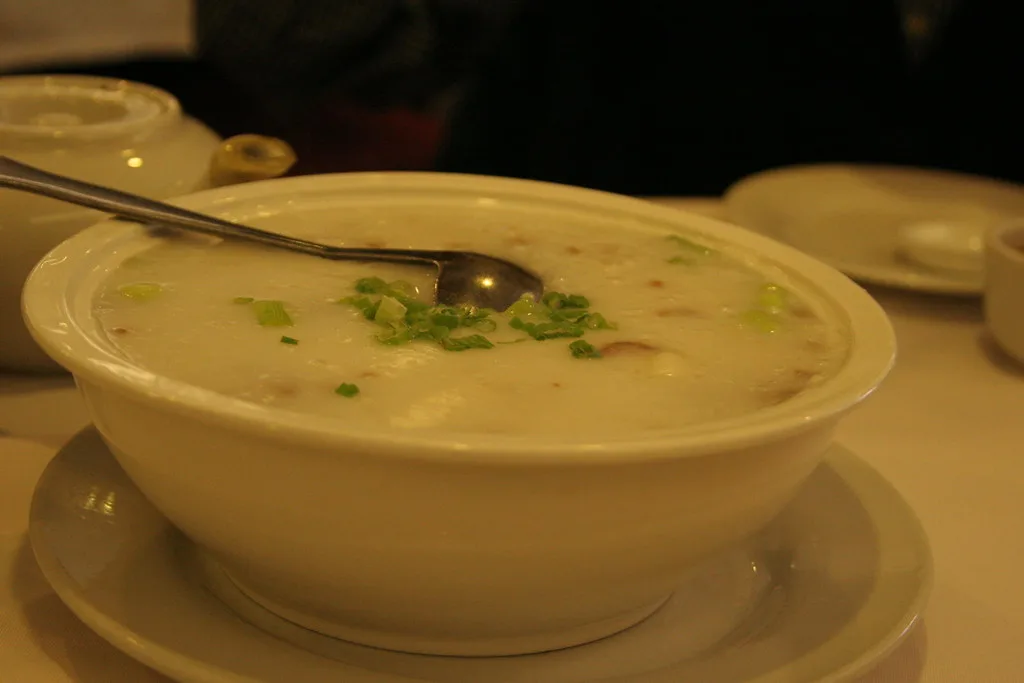 A bowl of plain rice congee topped with chopped scallions