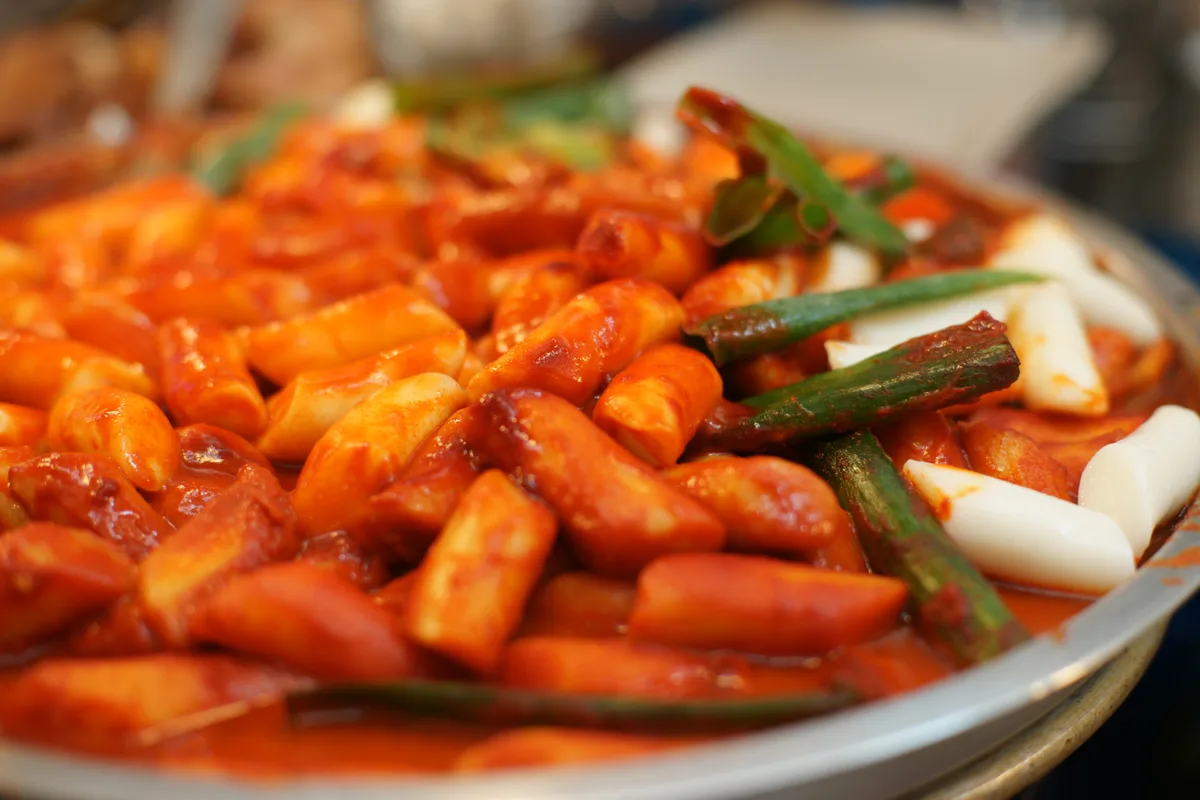 Tteokbokki, pastelitos de arroz cubiertos con una salsa espesa y roja de gochujang con cebollita