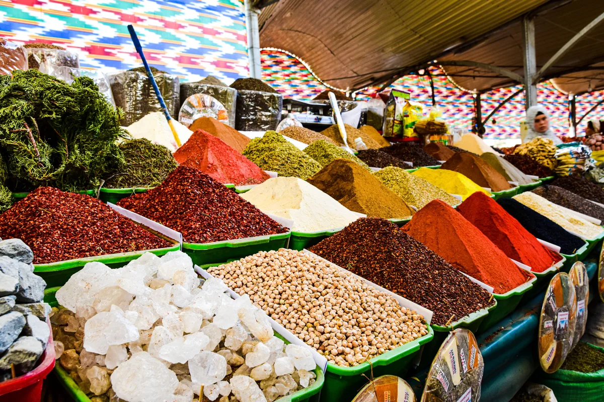 A market stall piled with ground spices, dried herbs and pale crystals