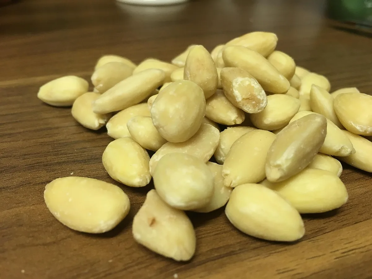 Peeled white almond kernels on a wooden table