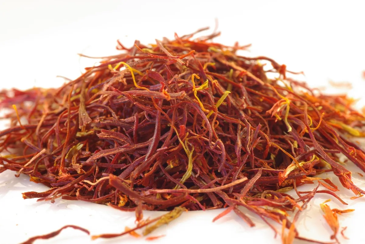 A loose pile of deep red saffron threads with pale yellow tips